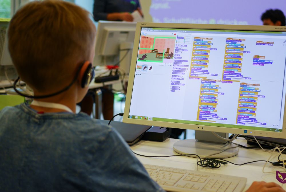 Kind verwendet die Proframmierumgebung Scratch am Computer um einen Film nach eigenem Drehbuch zu erstellen