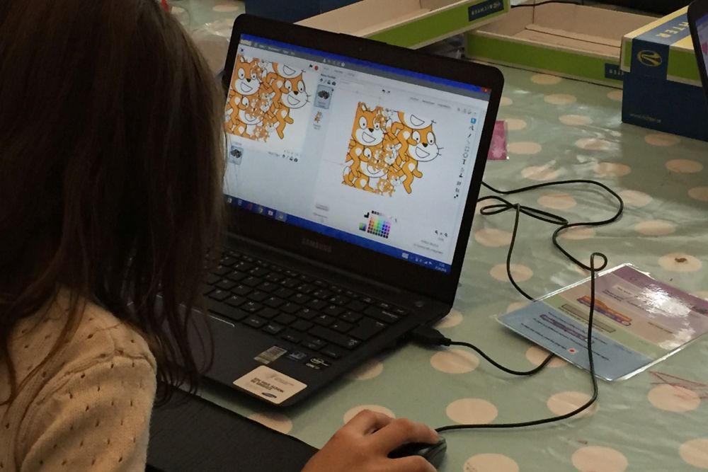 Kind verwendet die Proframmierumgebung Scratch am Computer um einen Film nach eigenem Drehbuch zu erstellen