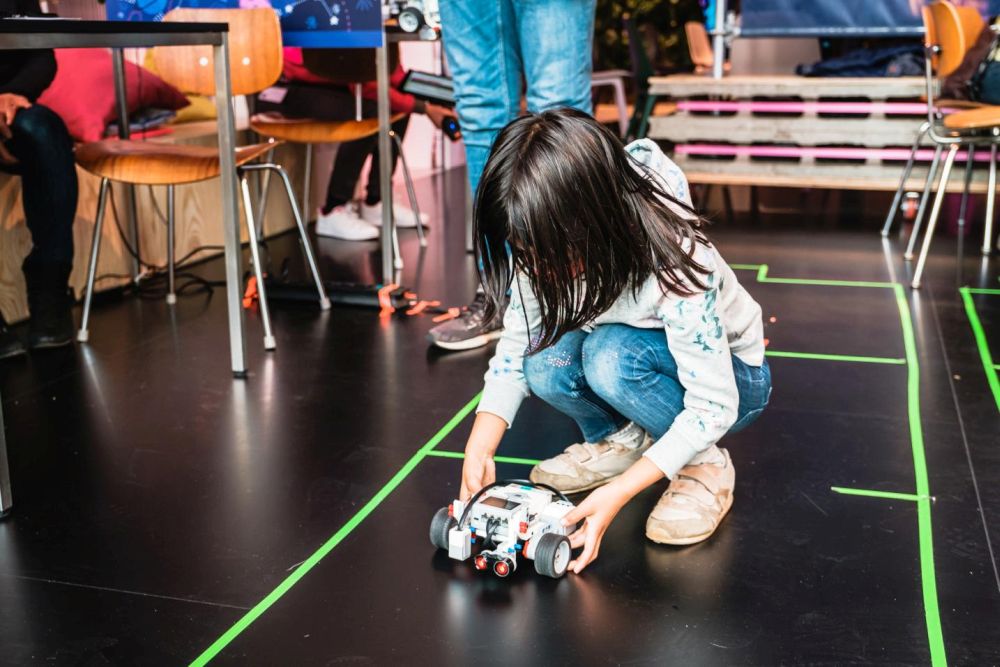 Kind setzt selbstgebauten und programmierten Roboter in die Rennstrecke