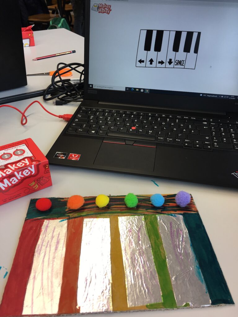 aus Pappe gebasteltes Musikintrument, farbig bemalt erzeugt mit Makey Makey und Laptop Musik