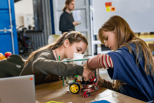 Mädchen bauen und programmieren einen Roboter bei der TüftelAkademie
